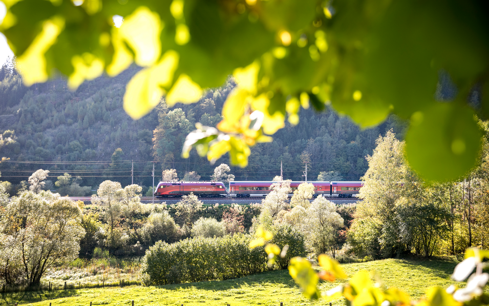 Ein Zug fährt durch die Landschaft in Österreich