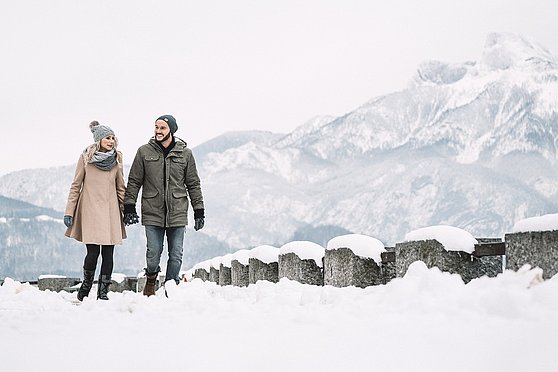 Foto Oberösterreich Tourismus GmbH/Robert Maybach: Paar beim Winterspaziergang an der Mondsee Uferpromenade im Salzkammergut.